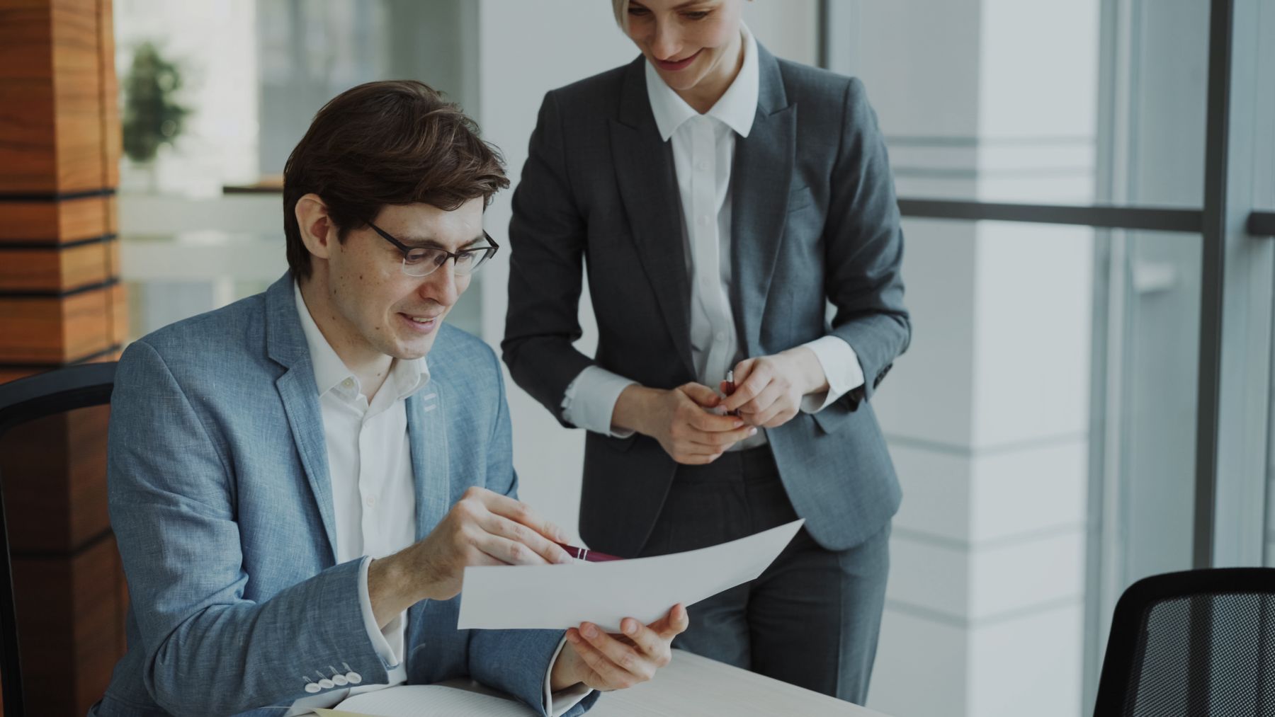 Two colleagues reviewing work together at a desk