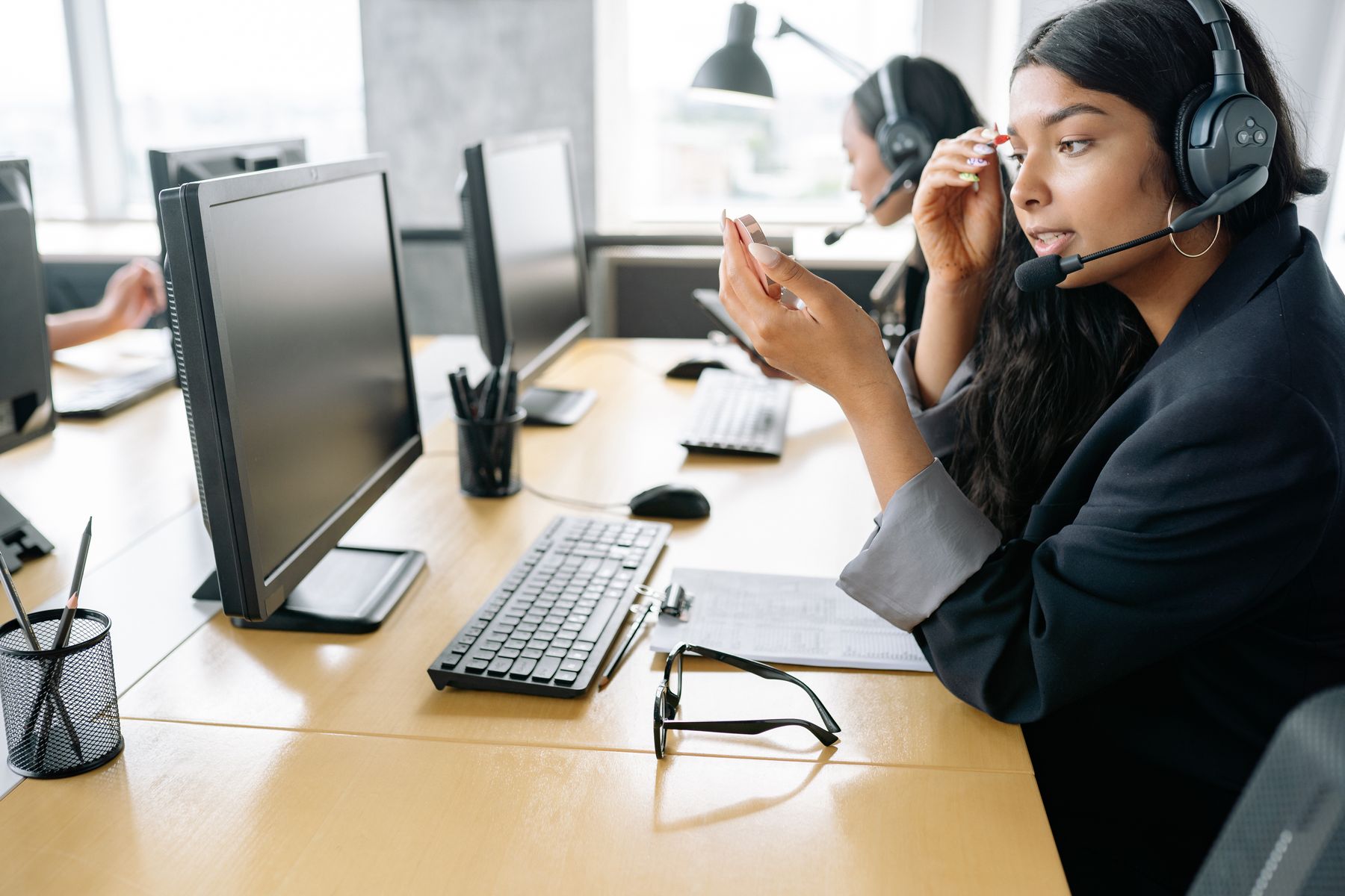 A professional speaking with a caller at a computer workstation